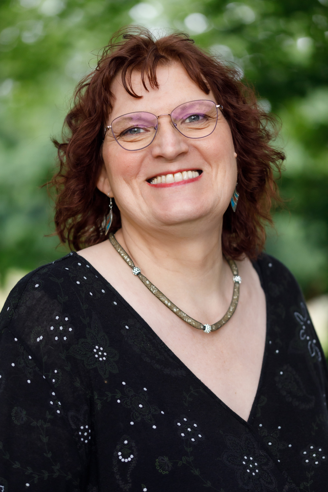 Porträt von Nicole Wittfoot, lächelnd im Grünen